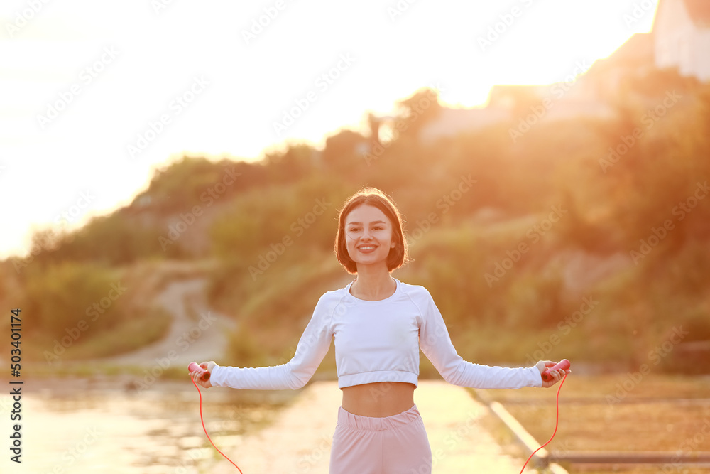 河边一个带跳绳的运动型年轻女子