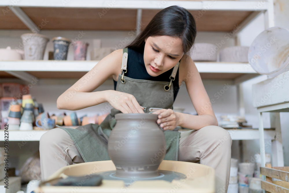 Close up of asian artist ceramist female hands working on potters wheel,asian female sculpture woman