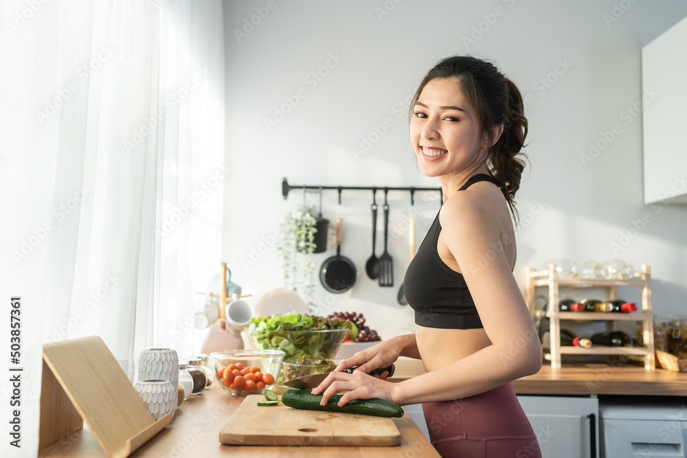 亚洲美女烹饪沙拉并看着镜头的肖像