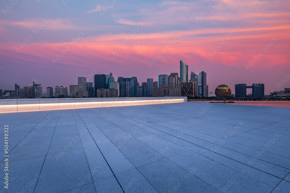 中国杭州夜晚空旷的广场层和城市天际线，现代商业建筑。