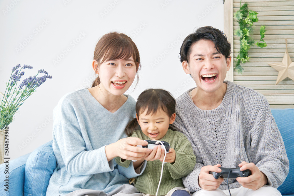 両親と娘　テレビゲームで遊ぶ　リビング