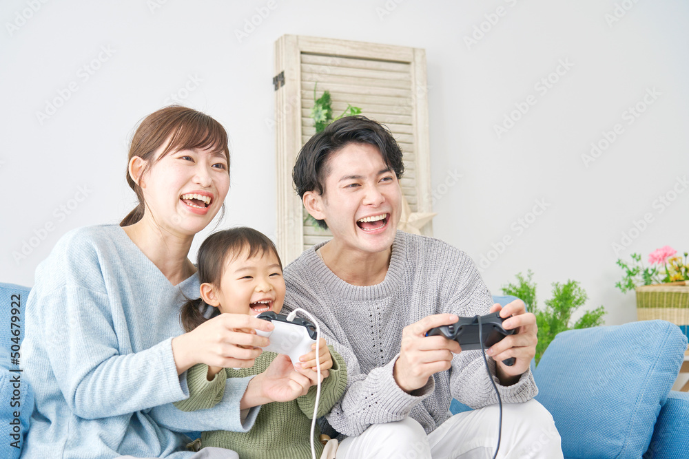 両親と娘　テレビゲームで遊ぶ　リビング