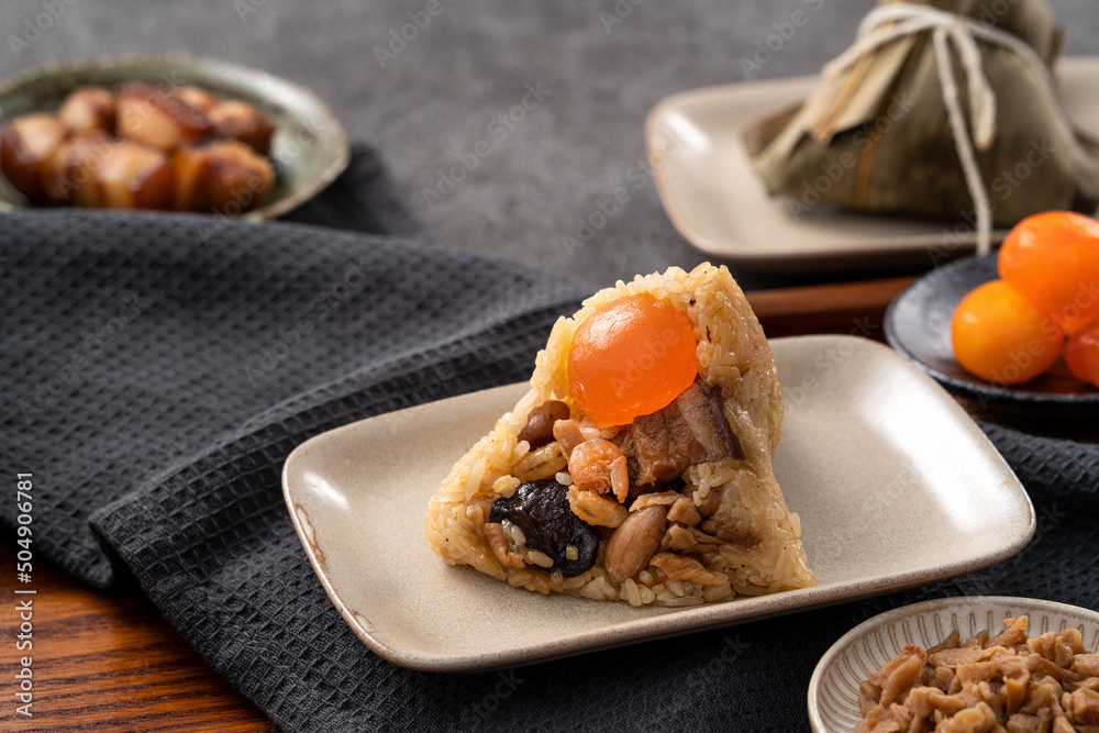 Zongzi, rice dumpling for Dragon Boat Festival on dark gray table background with ingredient.