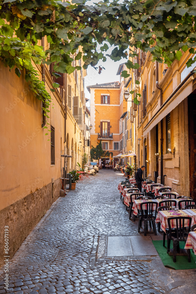 Narrow street with cafe and small shops in Rome. Italy travel concept, visiting cozy places