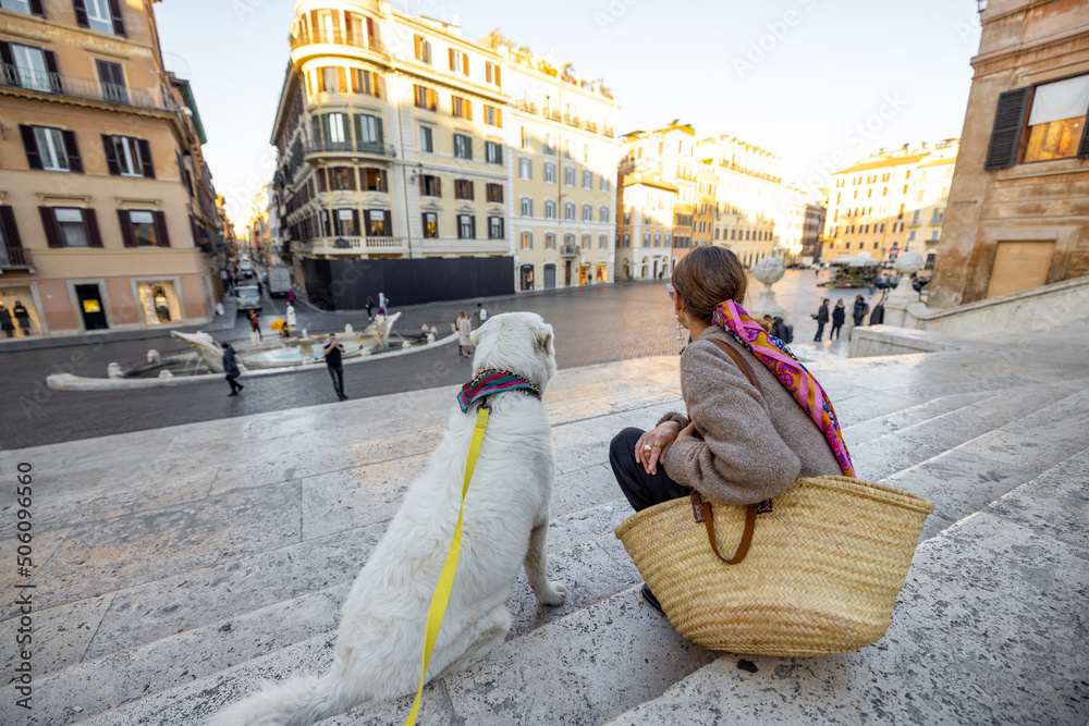 Woman sitting with her white dog on famous Spanish steps in Rome. Elegant woman dressed in italian o