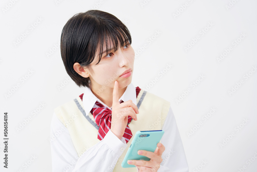 白背景でスマホをもって考える女子高生