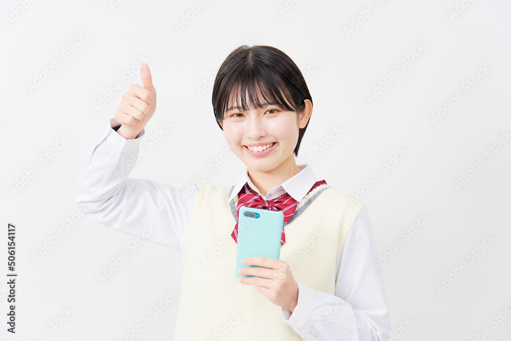 白背景でスマホを持ってグッドサインをする女子高生