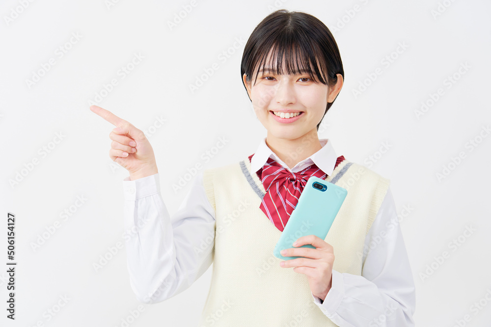 白背景でスマホを持って指差す女子高生