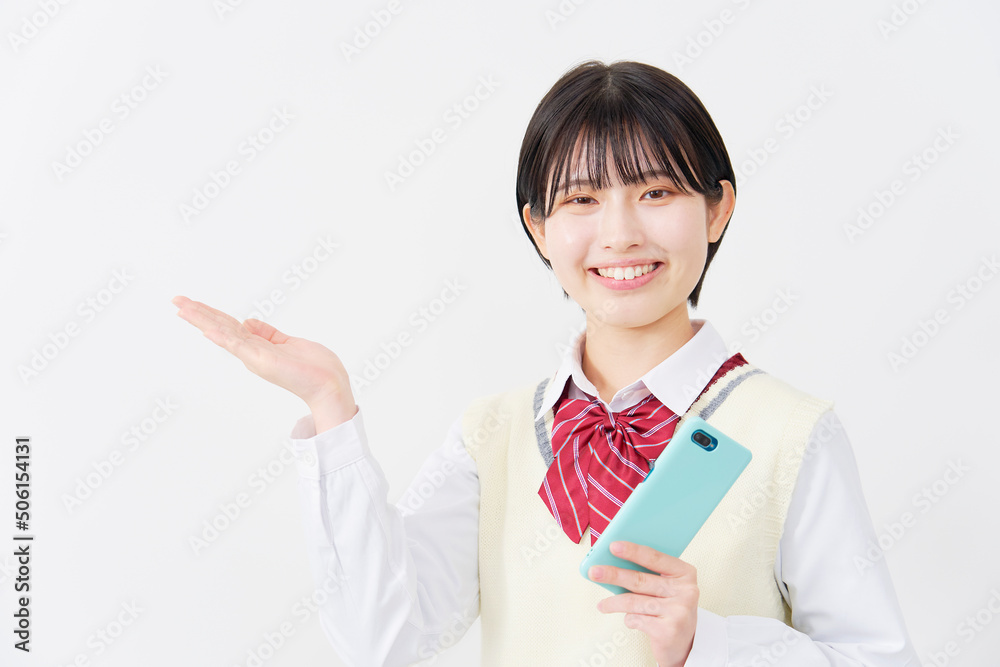 白背景でスマホを持って手のひらで指す女子高生