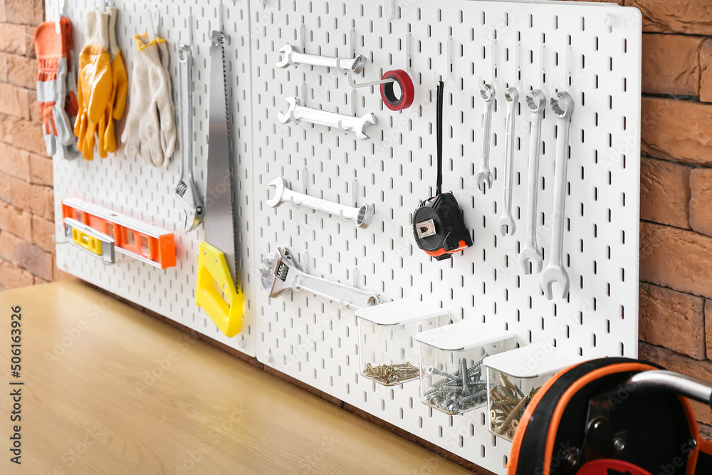 Pegboard with modern tools in workshop, closeup