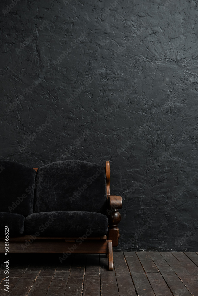 Black couch near dark wall