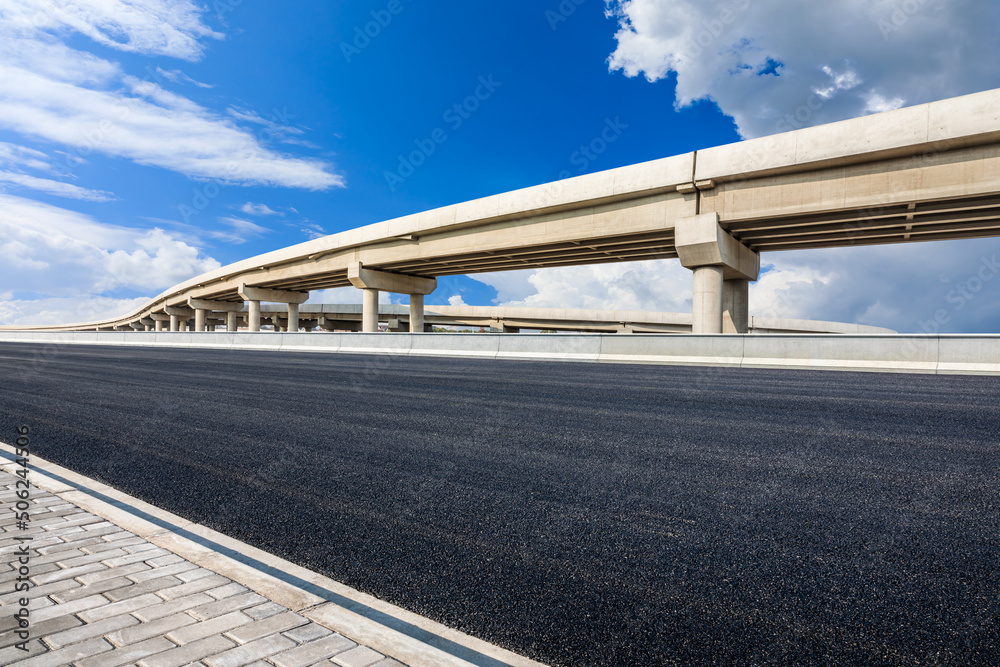 Asphalt highway and bridge under blue sky. Road and sky background.