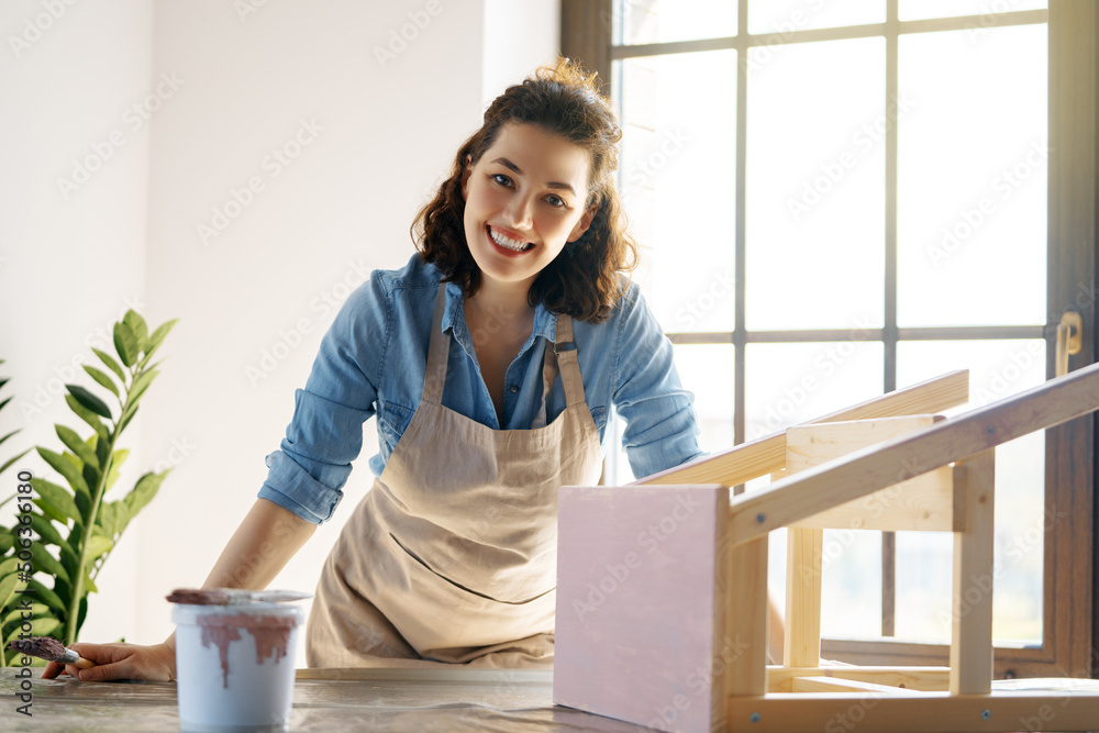 woman is painting a wooden stepladder