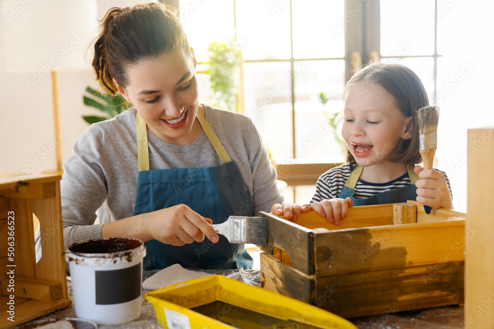 mother and daughter painting a wooden box