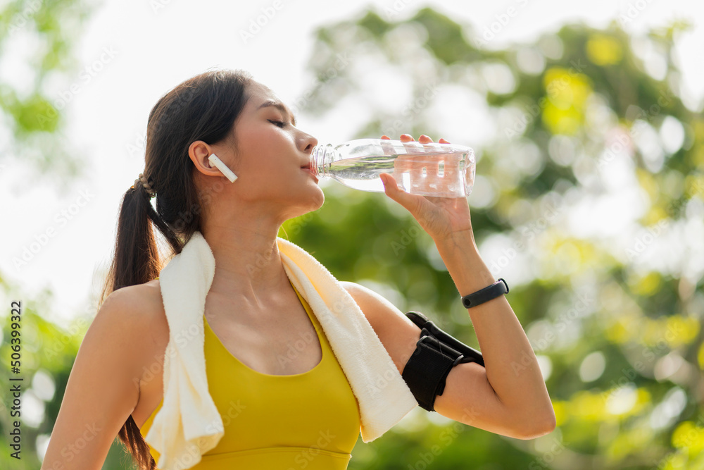 young Woman drinking water from bottle. asian female drinking water after exercises or sport. Beauti