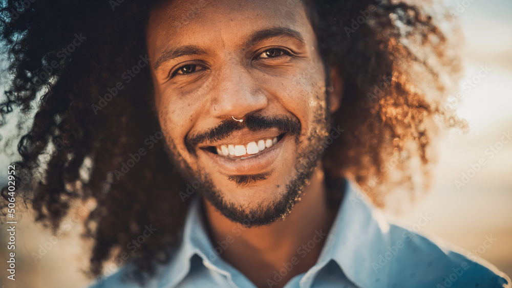 Close Up Portrait of a Happy Young Adult Male with Afro Hair and Nose Ring Piercing Posing for Camer