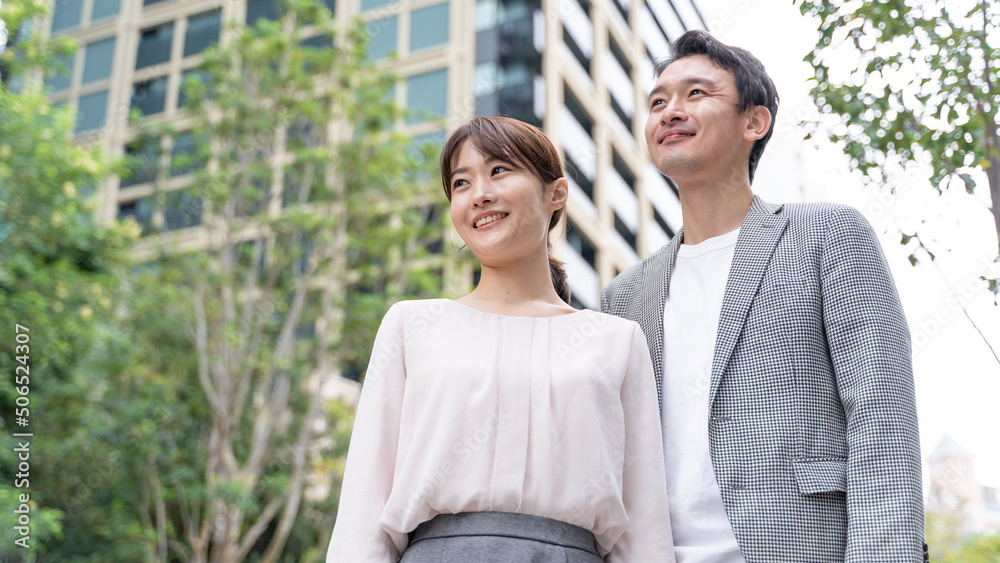 タワマンの前に立つカップルのポートレート