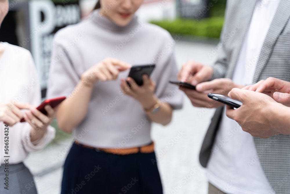 屋外でスマートフォンを使う人の手元