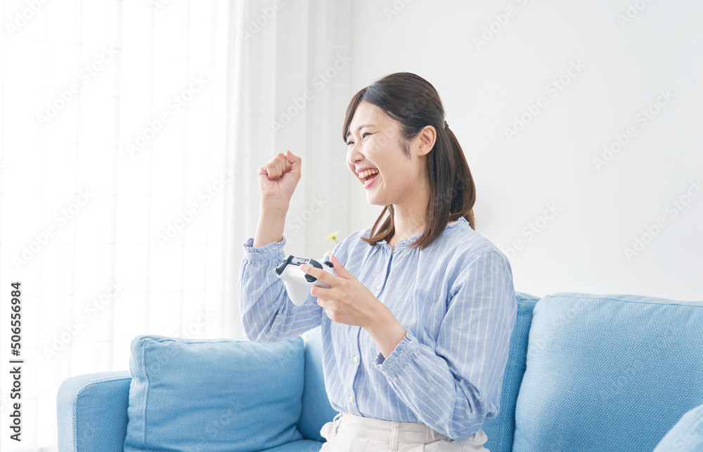 リビングでテレビゲームをして喜んでいる女性