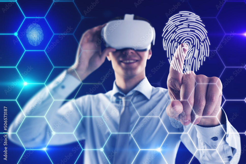 Attractive young european man with VR glasses on blue background with digital thumb print biometrics