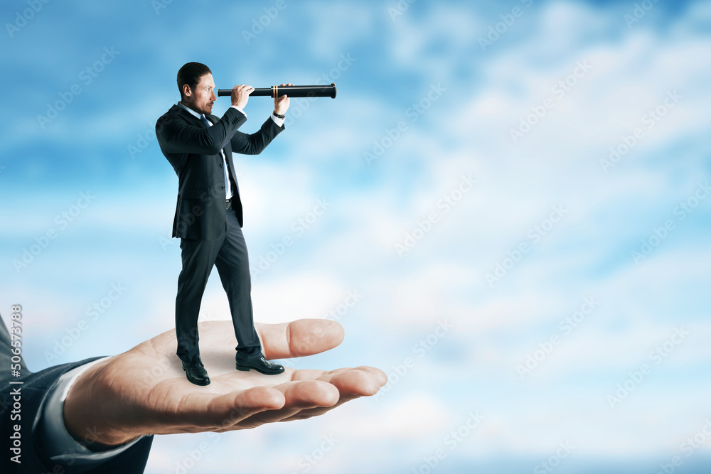 Abstract image of businessman with telescope looking into the distance while standing on palm. Futur