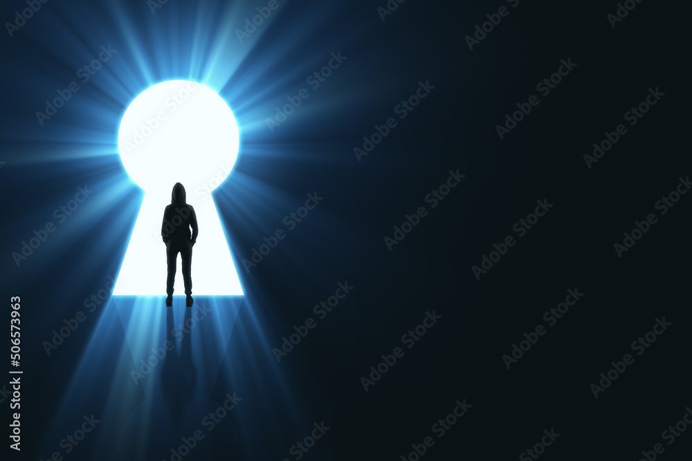 Backlit man in hoodie standing in bright keyhole opening on dark background with mock up place and l