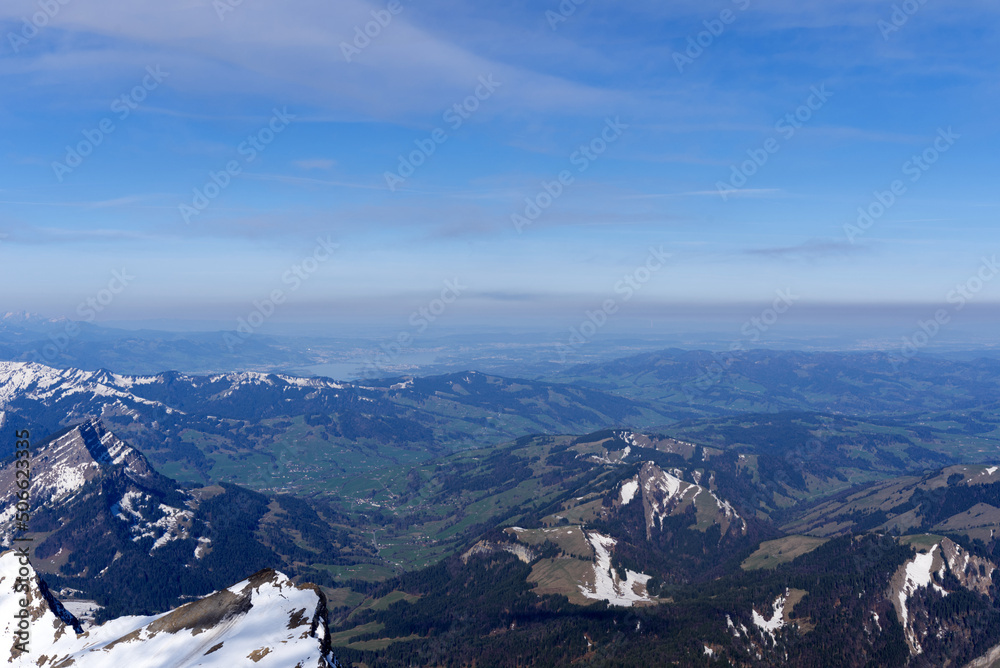 Panoramic landscape with rocks and hills with Lake Zürich in the background seen from Säntis peak at