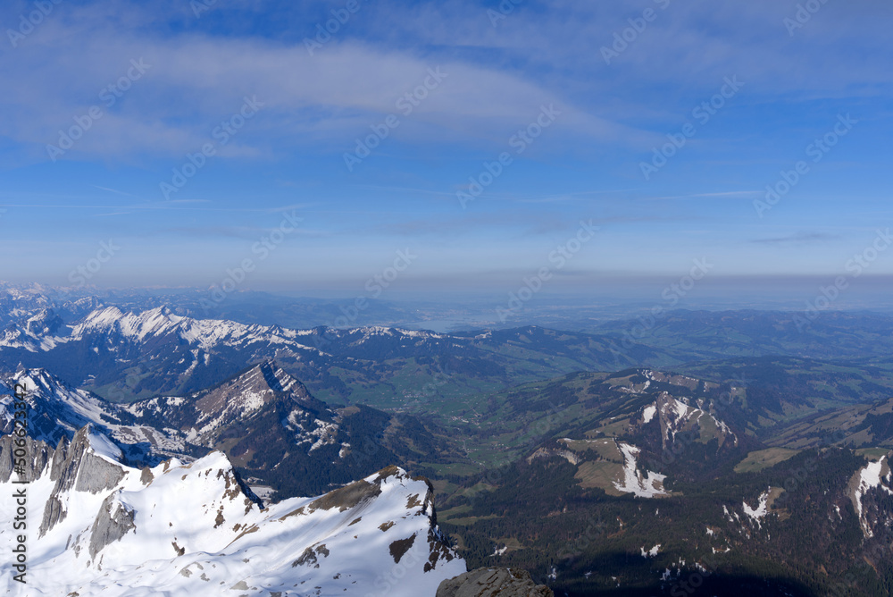 Panoramic landscape with rocks and hills with Lake Zürich in the background seen from Säntis peak at