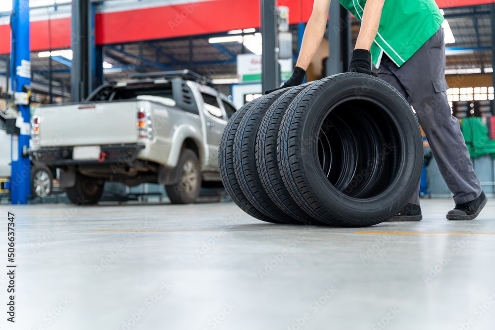 Auto Mechanic with 4 new tires that change tires in the auto repair service center.