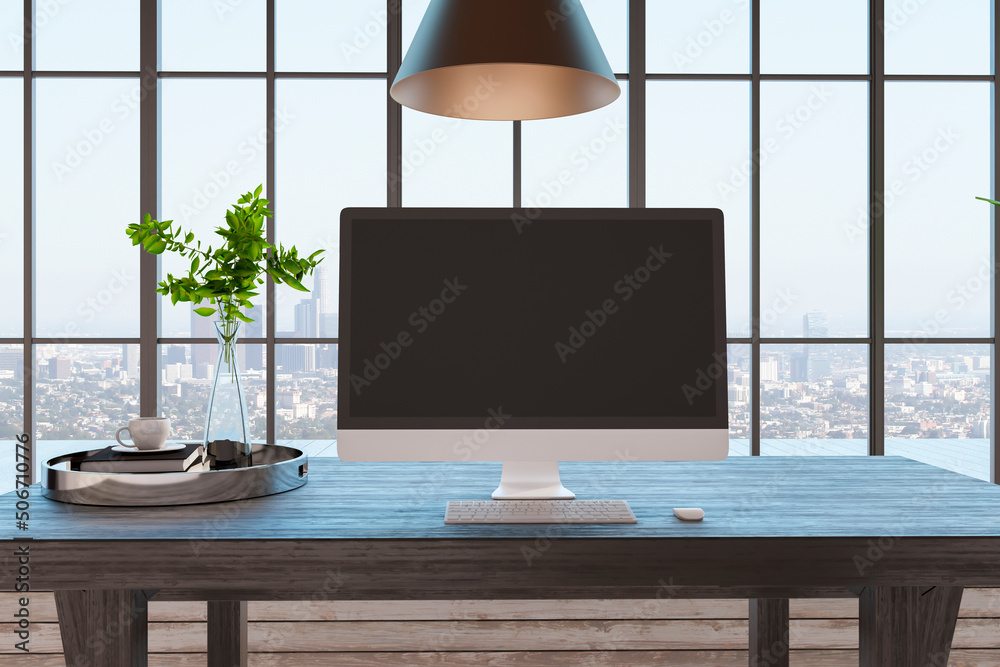 Front view on blank dark monitor screen on wooden table with green plants in glass vase and big wind