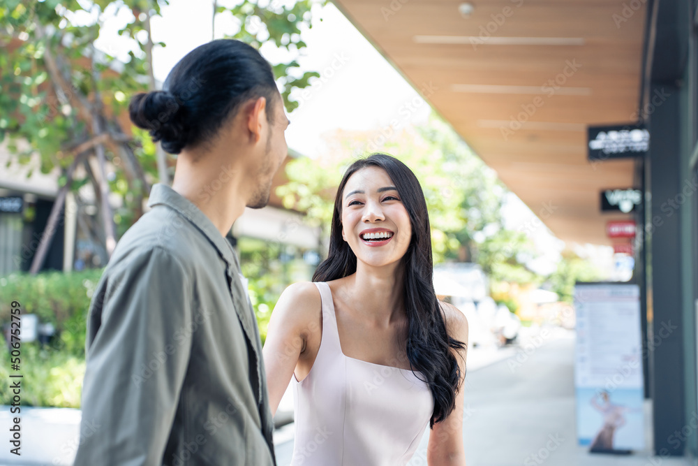 亚洲年轻男女在百货公司户外购物。