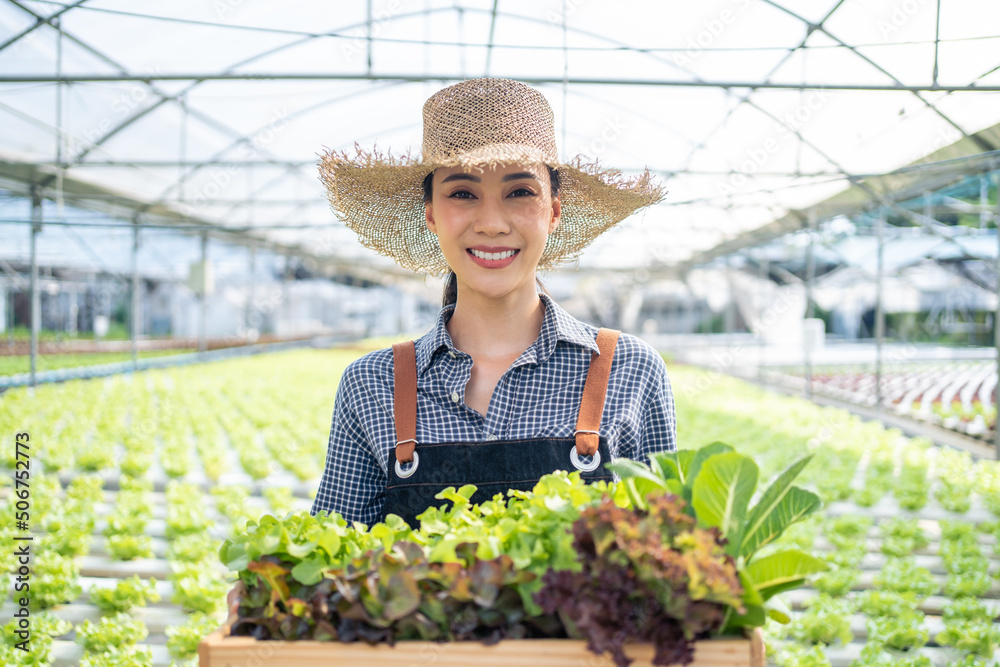 亚洲农民的画像——一位年轻女子在农场里拿着一篮子蔬菜。