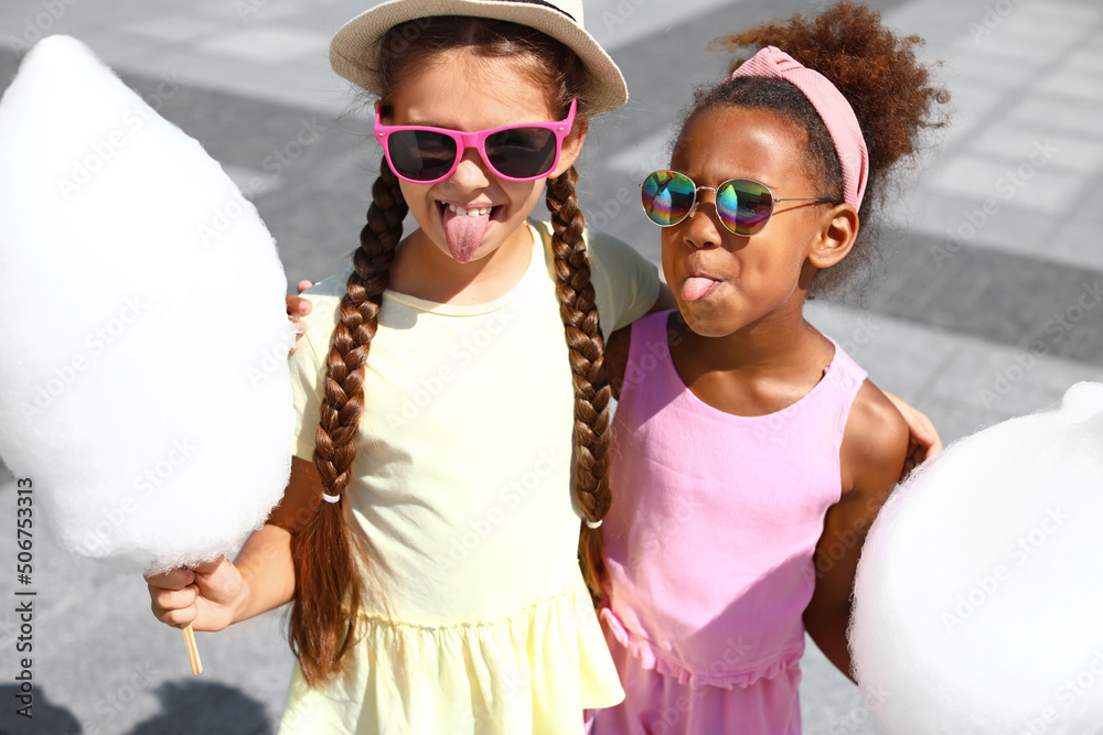 Cute little girls with cotton candy outdoors