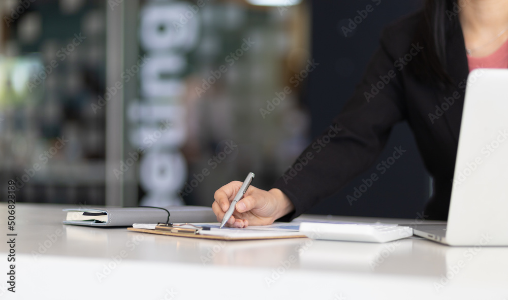 Businesswoman finance market analyst working on laptop pointing at business finance report chart doc