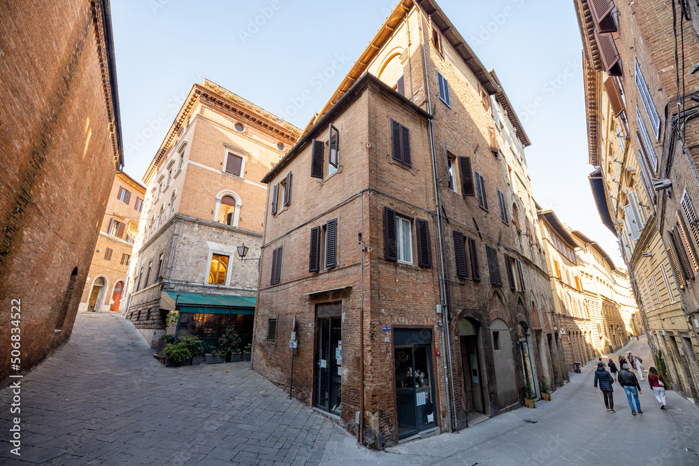 View on narrow and cozy street in the old town of Siena city in Italy. Concept of ancient architectu