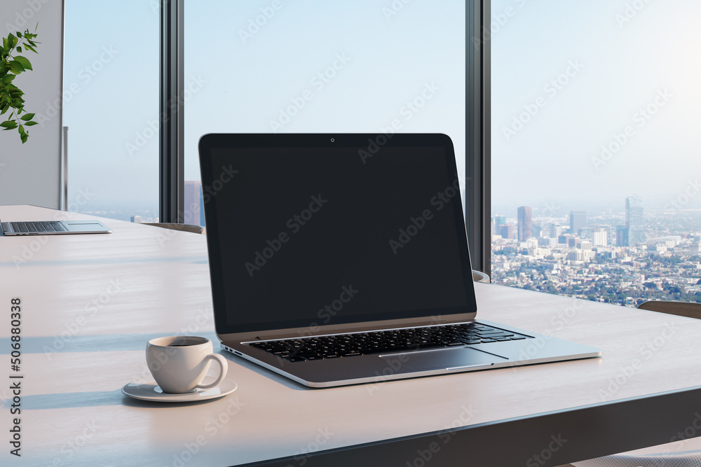 Blank black laptop screen with copyspace for your logo or text on light wooden table with coffee mug