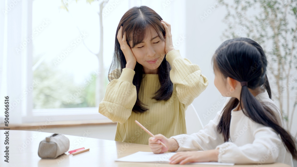 家で勉強をする女の子を見守るお母さん