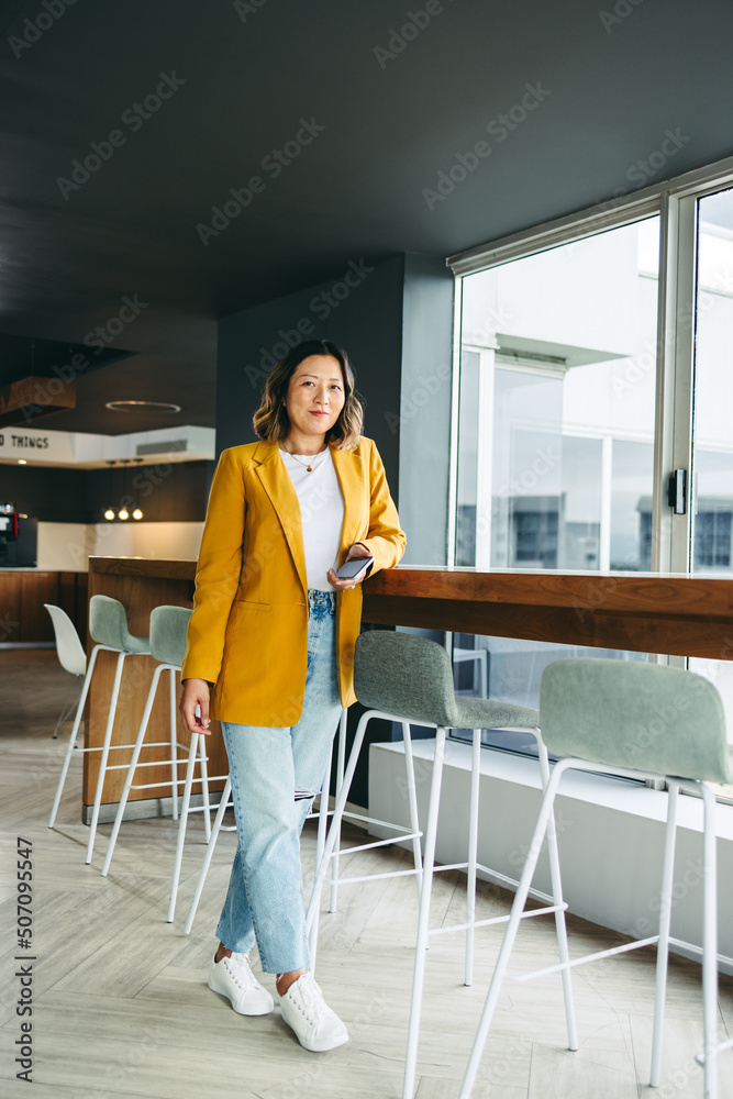 Cheerful businesswoman standing in a co-working office