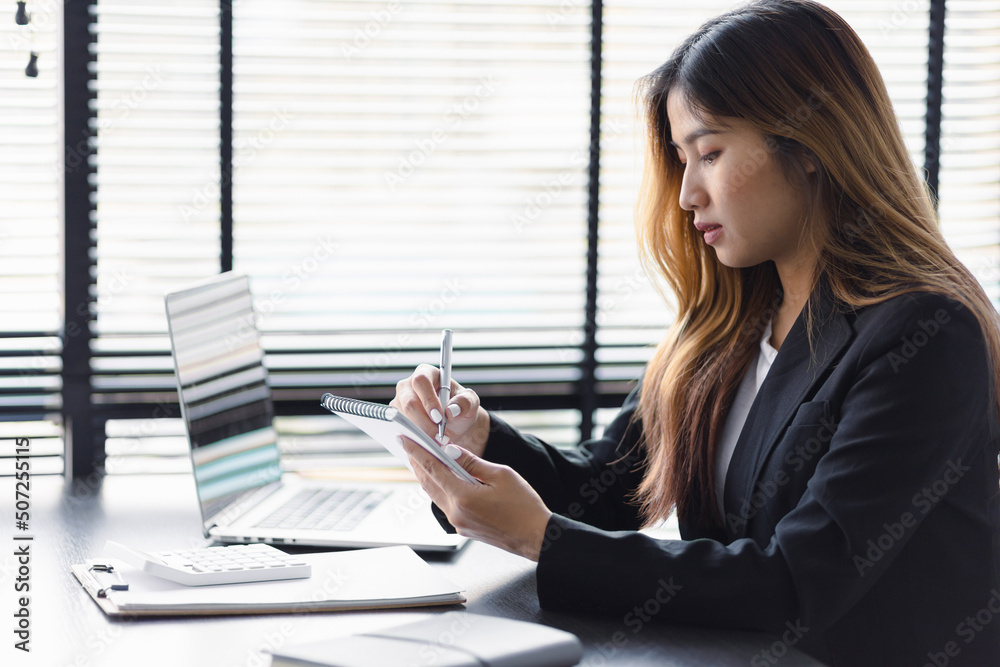 Business woman working in an office writes financial and accounting records. Accountant is working i