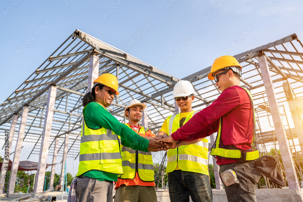 建筑师和工程师施工人员在户外施工现场携手合作。