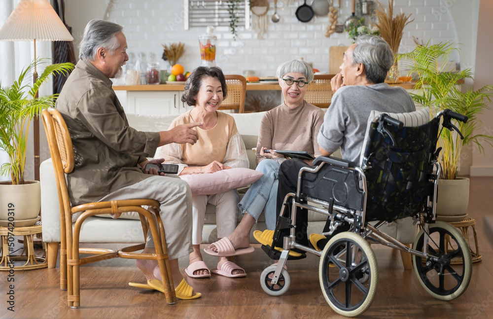 Group Asian seniors friends are sitting in the living room of a home together, enjoying talking toge