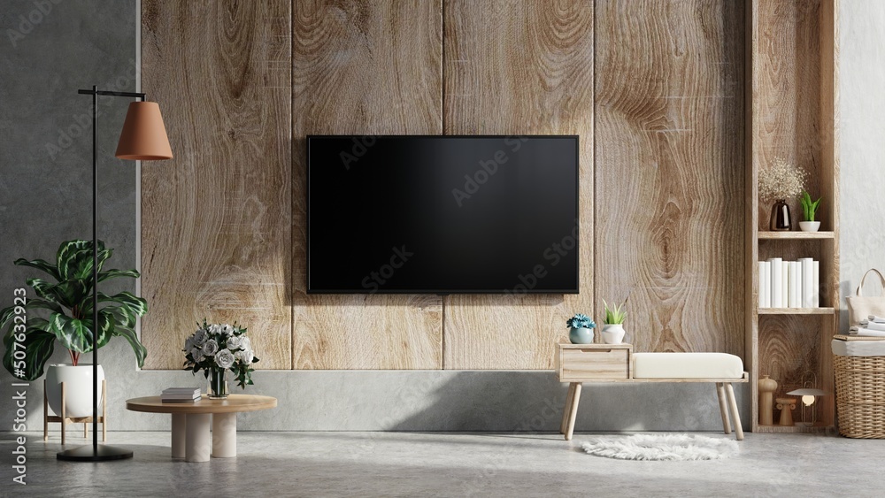 Wooden wall mounted tv in modern living room with accessories decoration on concrete background.