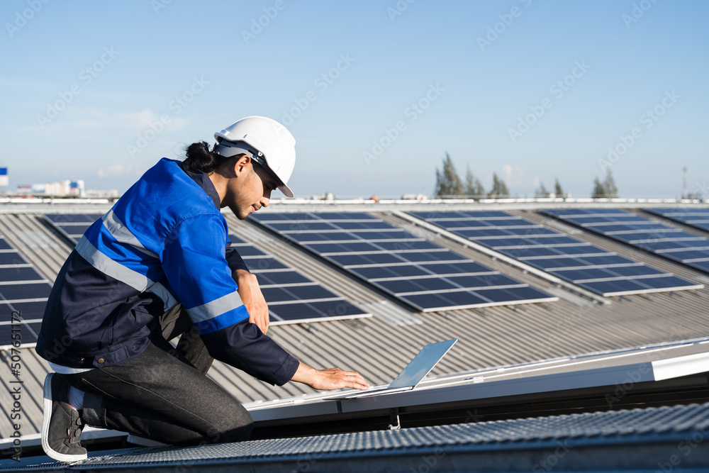 亚洲技术人员在光伏背景场安装检查或维修太阳能电池板