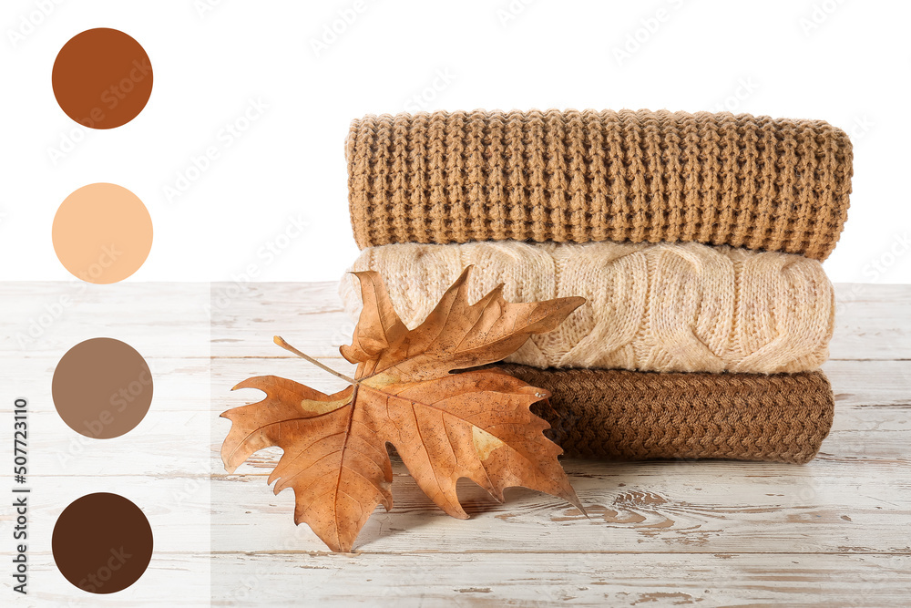 Stylish autumn clothes on table against white background. Different color patterns