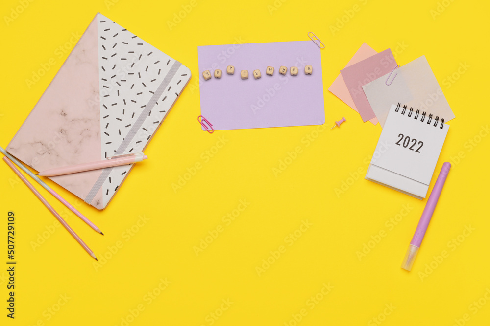 Stationery supplies with word SEPTEMBER and calendar on yellow background