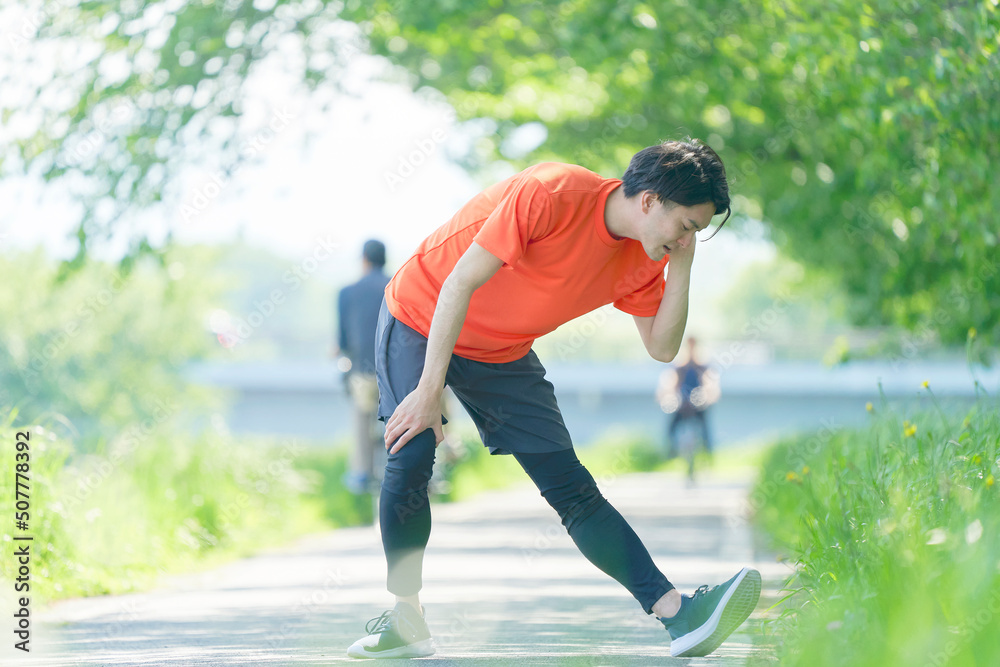 屋外で運動の準備運動をする男性