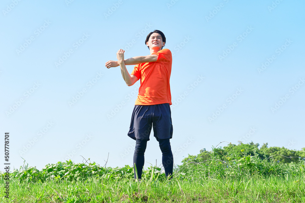 屋外で準備運動する男性