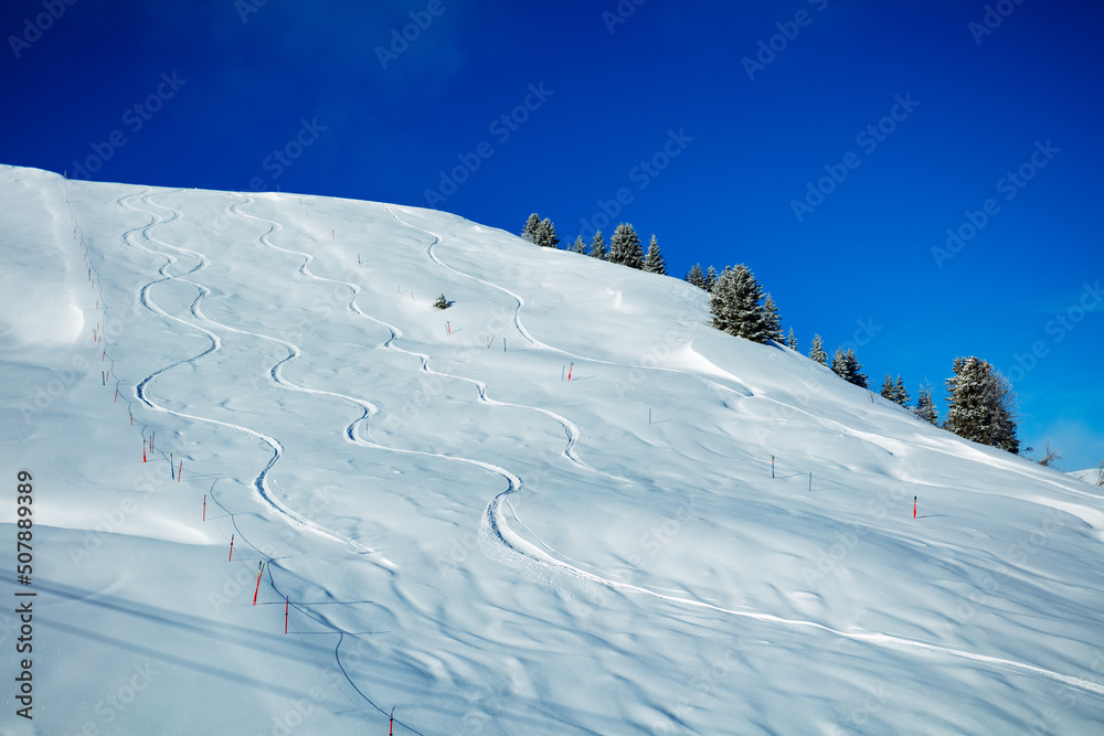 在蓝天上的山上滑雪的痕迹