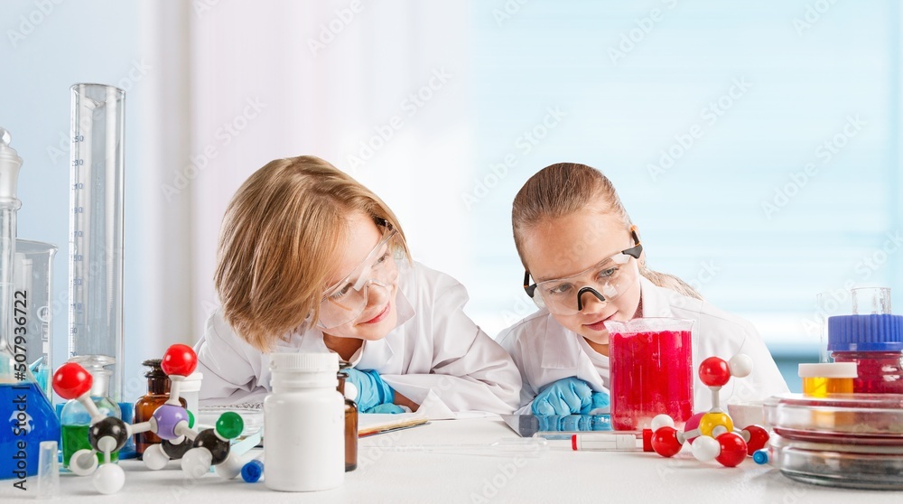 Excited Kid conducting a scientific experiment  or chemical reaction at chemistry laboratory