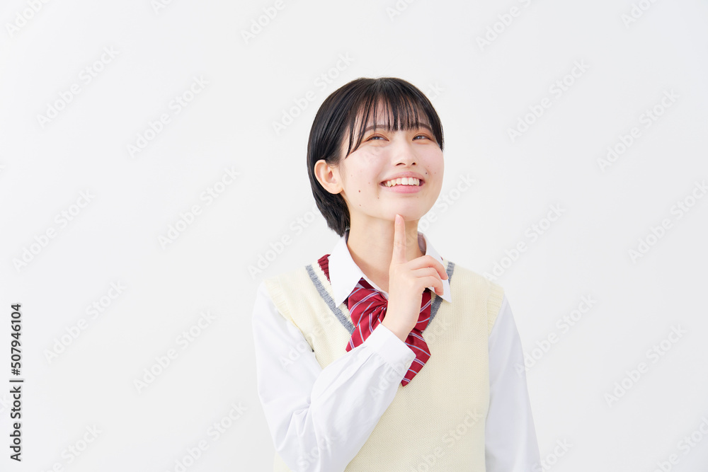 白背景で笑顔で考える女子高生